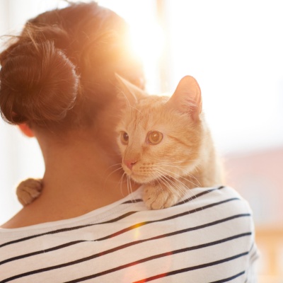 femme calinant son chat roux
