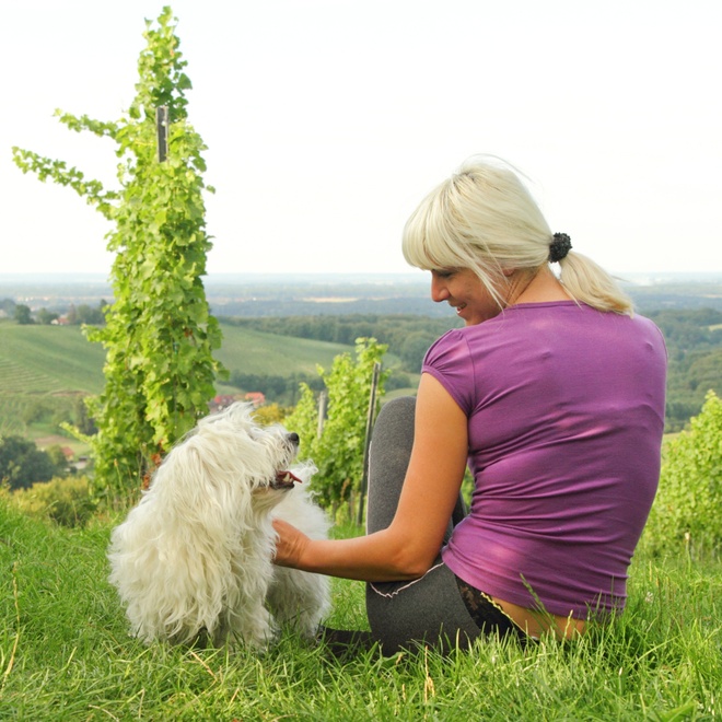 a Coton de Tulear sitting with its owner who cuddles it