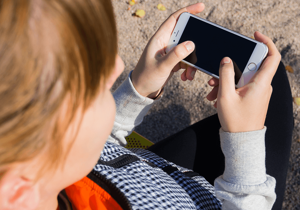 Une enfant avec un smartphone dans les mains