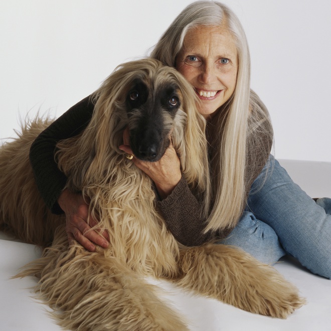 an afghan hound next to its owner on a sofa