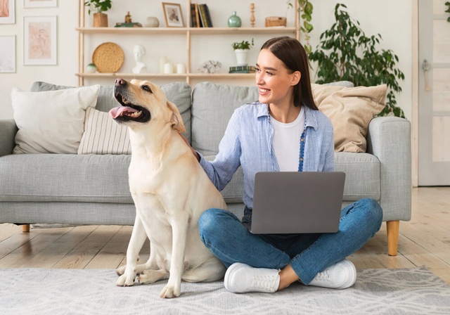 woman working on the computer with her dog